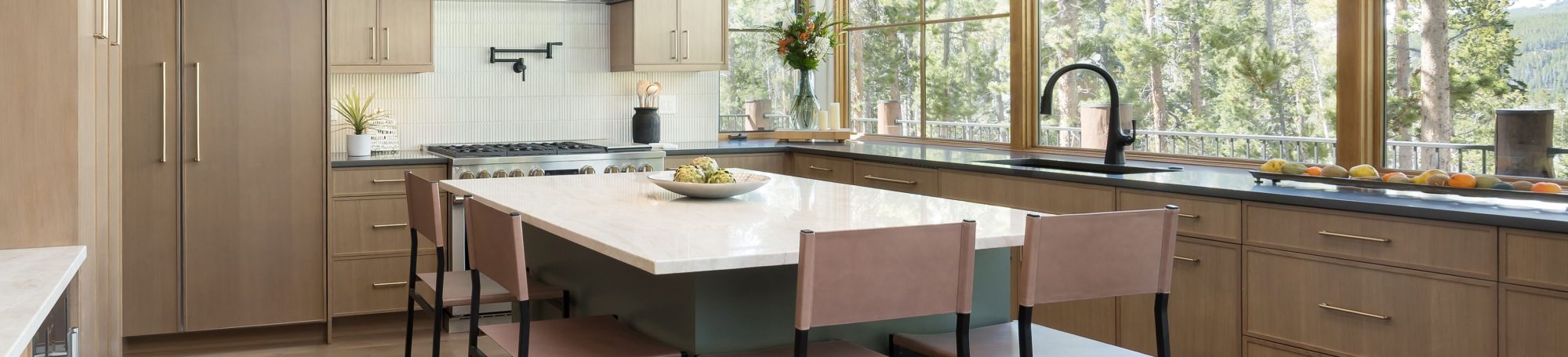 This is a picture of a kitchen featuring rift cut white oak cabinets in the perimeter and a custom green painted island.