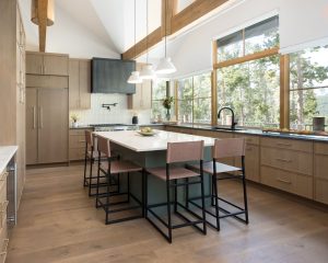 This is a picture of a kitchen featuring rift cut white oak cabinets in the perimeter and a custom green painted island.