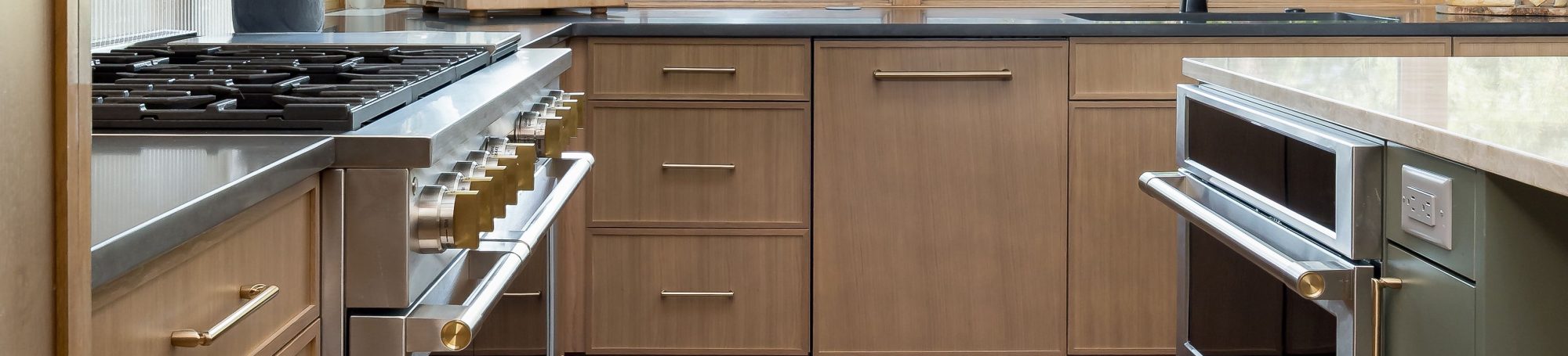 This is a picture of a kitchen featuring rift cut white oak cabinets in the perimeter and a custom green painted island.