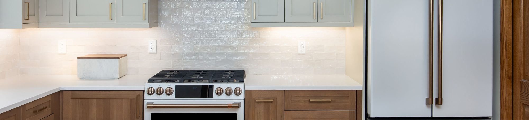 This is a kitchen featuring white oak and painted cabinetry.