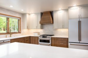 This is a picture of a kitchen featuring white oak and painted cabinetry