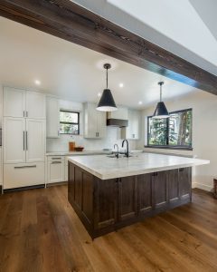 This is a picture of a kitchen featuring Bridgewood cabinetry The island has Maple cabinetry with Java stain and a painted accessible beige perimeter.